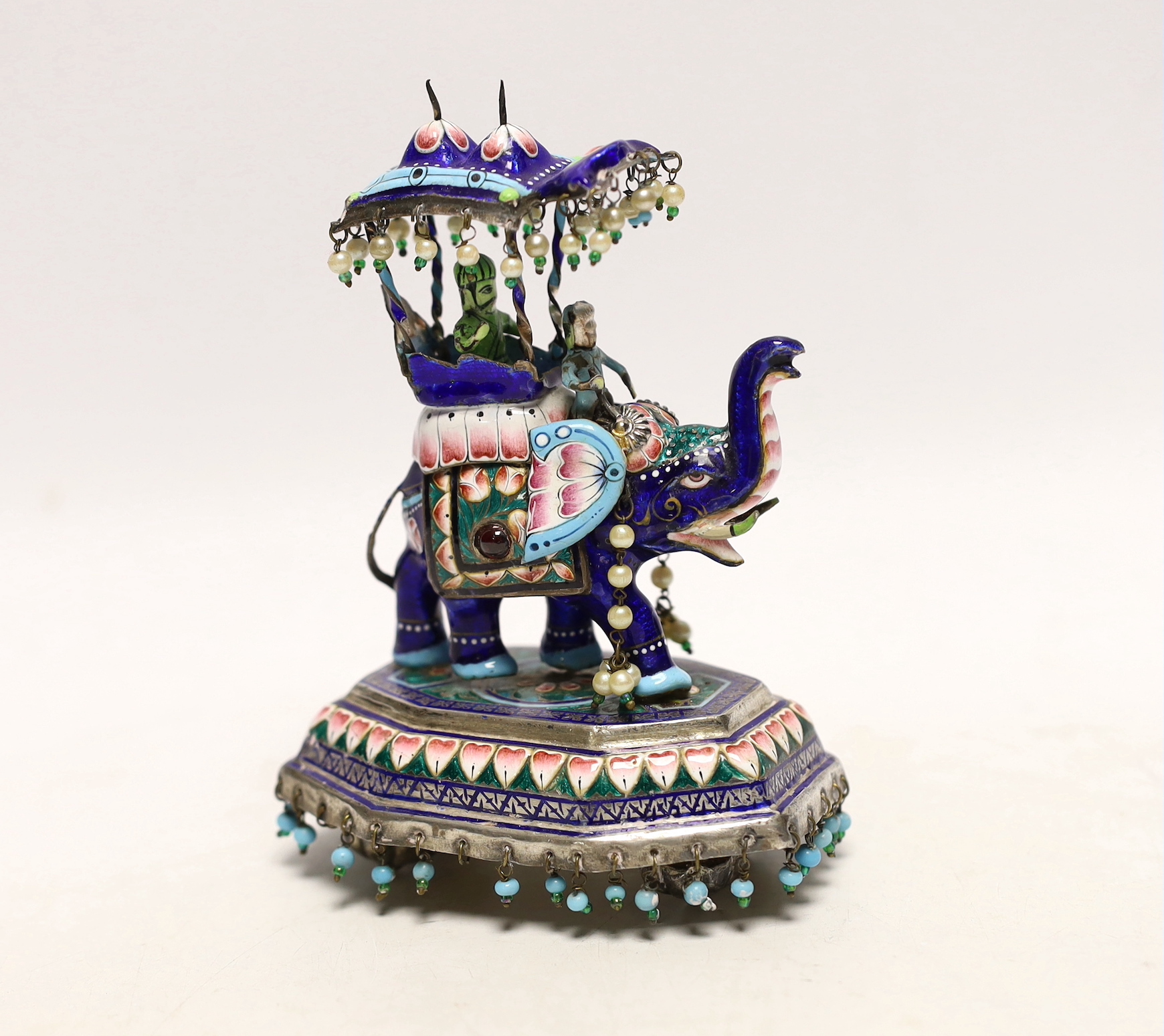 An Indian? white metal, polychrome enamel and gem set model of an elephant with Howdah, on octagonal base, length 96mm.